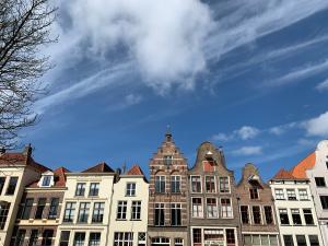 uma fila de edifícios com um céu azul ao fundo em Stadshotel aan de IJssel in hartje Deventer em Deventer