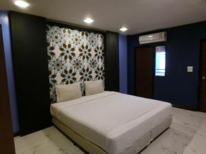 NewYork Suite Hotel في Ban Ko: غرفة نوم بسرير ابيض كبير وبجدار