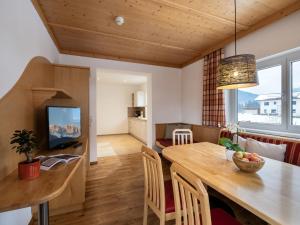 ein Esszimmer und ein Wohnzimmer mit einem Holztisch in der Unterkunft Appartementhaus Fuchs in Itter