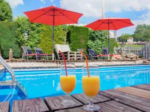 zwei Gläser Orangensaft auf einem Tisch neben einem Pool in der Unterkunft Grub-Daniel-Hof in Freiamt