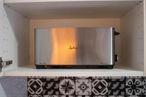 a microwave oven sitting on a shelf in a kitchen at Ático con terraza en Cuesta Gomérez in Granada