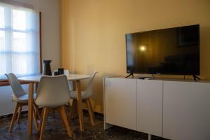 a living room with a table and a large television at Ático con terraza en Cuesta Gomérez in Granada