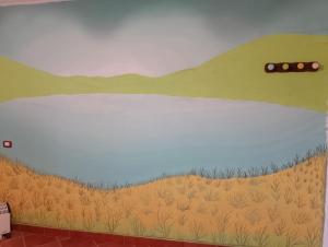 uma parede com um mural de um campo em Fòndaco Pietramonte em Baselice