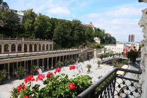 a view from a balcony of a plaza with red flowers at ASTORIA Hotel & Medical Spa in Karlovy Vary