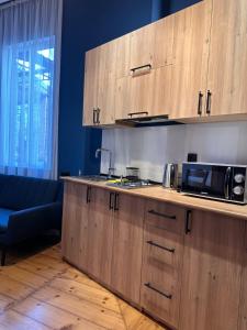 - une cuisine avec des placards en bois et un four micro-ondes dans l'établissement Apartment Riverside, à Koutaïssi
