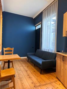 - un salon bleu avec un canapé et une table dans l'établissement Apartment Riverside, à Koutaïssi