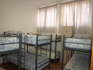 a group of bunk beds in a room with windows at Hostel Rural David Broncano in Orcera