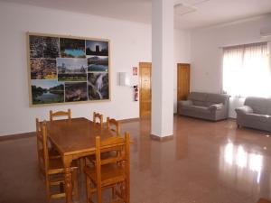 un soggiorno con tavolo, sedie e divano di Hostel Rural David Broncano a Orcera