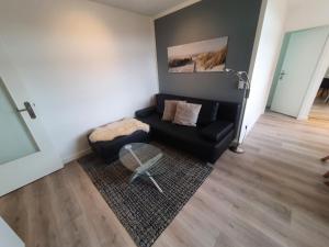 a living room with a couch and a table at Haus Uthlande Haus Uthlande Whg 44 Kutter in Südstrand