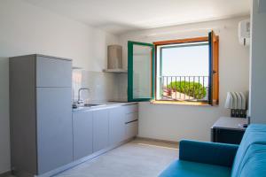 a kitchen with a blue couch and a window at Residence Playa in Tortoreto Lido