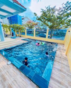 two children swimming in a pool at a resort at SON'S VILLA VUNG TAU in Vung Tau