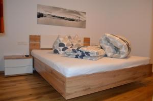 uma cama com almofadas num quarto em Appartement Dorfblick em Auffach