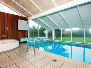a large swimming pool with a tub and a tv at 10 person holiday home in Alling bro in Nørager