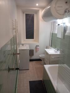 a bathroom with a sink and a toilet and a window at La Maison d Antoine in Tarascon-sur-Ariège