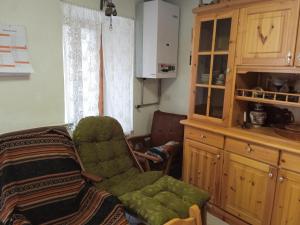 a living room with a green chair and a cabinet at IL SENTIERO in Pioraco