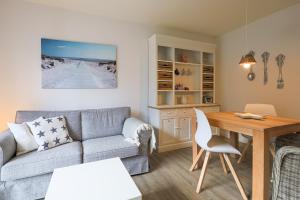 - un salon avec un canapé et une table dans l'établissement Appartement Seesternchen, à Wenningstedt