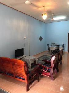a living room with a couch and a table and chairs at Homestay Che Mat in Kuala Terengganu