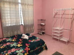 a bedroom with a bed with a black blanket and a shelf at Homestay Che Mat in Kuala Terengganu