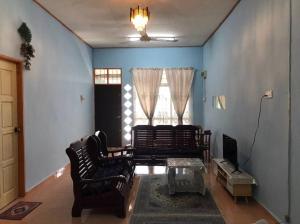 a living room with two chairs and a table at Homestay Che Mat in Kuala Terengganu