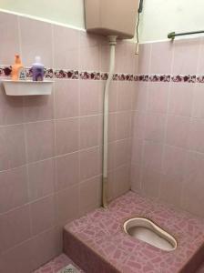 a pink tiled bathroom with a pink toilet in it at Homestay Che Mat in Kuala Terengganu