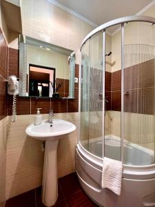 a bathroom with a sink and a shower at IRIS Hotel in Chişinău