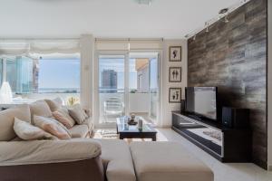 un soggiorno con un divano e una TV di Playamar a Torremolinos