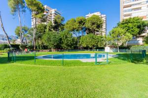 una piscina in un parco con prato e edifici di Playamar a Torremolinos