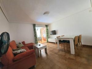 ein Wohnzimmer mit einem Sofa und einem Tisch in der Unterkunft Apartamento CULLERA in Faro de Cullera