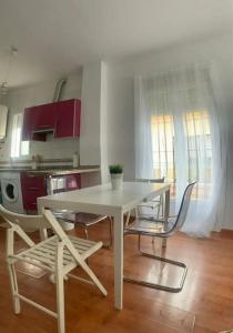 einen weißen Tisch und Stühle in der Küche in der Unterkunft Apartamento luminoso en Espartinas Totalmente climatizado in Espartinas