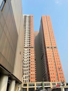 zwei hohe Gebäude in einer Stadt mit in der Unterkunft Apartemen Transpark Juanda Bekasi by Cheapinn in Padurenan