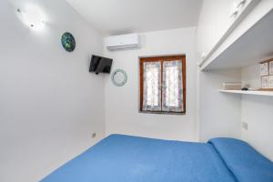 a bedroom with a blue bed and a window at La finestra sul mare in Budoni