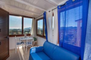 uma sala de estar com um sofá azul e uma mesa em La finestra sul mare em Budoni