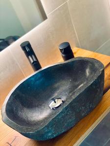 Chalet Badberg في باد جاستاين: حوض أسود على منضدة خشبية في الحمام