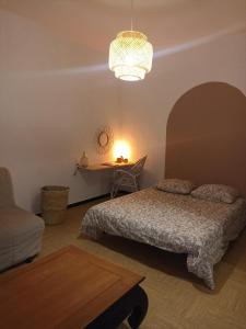 een slaapkamer met een bed, een tafel en een lamp bij hébergement de la plage en ville in Martigues