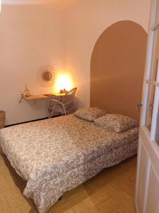 een slaapkamer met een bed en een tafel met een spiegel bij hébergement de la plage en ville in Martigues
