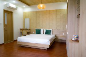 a bedroom with a large white bed in a room at Bambu Hotel in Da Nang