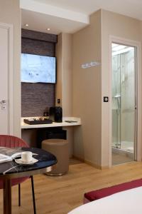 a living room with a table and a screen at Hôtel Tourisme Avenue in Paris