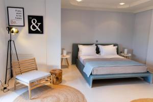 una camera da letto con un letto e una sedia di Casa Grande Private Luxury Villa a Alykes Potamou