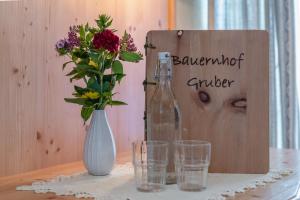 un tavolo con bottiglia e bicchieri e un cartello di Erlebenswert Bauernhof Gruber a Sankt Lorenzen im Lesachtal