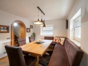 - une salle à manger avec une table en bois et un canapé dans l'établissement Haus Milan, à St. Johann in Tirol