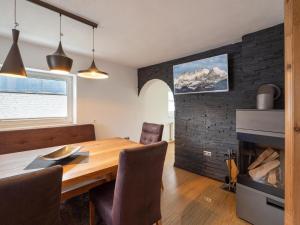 a dining room with a table and a fireplace at Haus Milan in Sankt Johann in Tirol