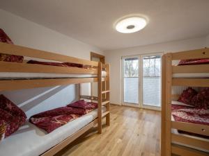 a room with three bunk beds and a window at Haus Milan in Sankt Johann in Tirol