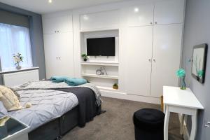 Schlafzimmer mit einem Bett und einem Flachbild-TV in der Unterkunft East Shore in Hastings