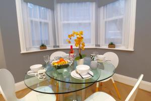 een glazen eettafel met witte stoelen bij East Shore in Hastings