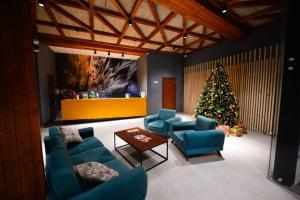 a living room with a christmas tree and blue chairs at The Charmer @ The Valley in Bakuriani
