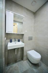 een badkamer met een wit toilet en een wastafel bij The Charmer @ The Valley in Bakuriani