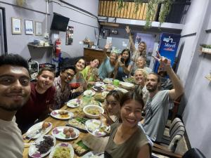 a group of people sitting around a table eating food at Asleep Hostel in Kanchanaburi