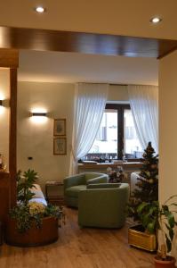 a living room with two chairs and a christmas tree at Hotel Wanda in Pinzolo