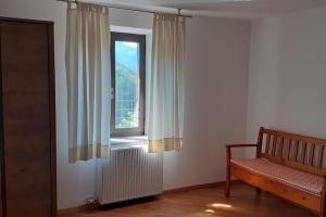 um quarto com uma janela com um radiador e um banco em Cà dei Zoani casa vacanze 022139 AT 722787 em Pergine Valsugana