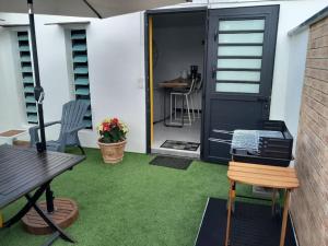 a patio with a table and chairs and a door at Côté Terrasse in Le Tampon